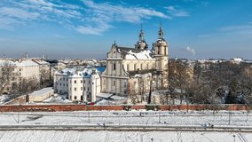 Krakow, Poland. Skalka, St. Stanislaus church na Skałce and Paulinite monastery in snow. Burial place of distinguished Poles. Aerial video in winter,  Boulevards and promenades with walking people