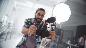 Slow Motion Portrait of a Male Videographer Using a Smartphone Rig on a Set and Giving Instructions to a Model While Filming a Commercial. Artist Using Digital Equipment For Making a Creative Video - Powered by Shutterstock - Get 15% off with code: PIKWIZARD15