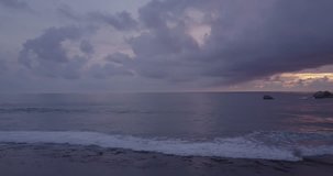 Top view on ocean with waves and rocks. Sunset. Slow move camera. D-log.