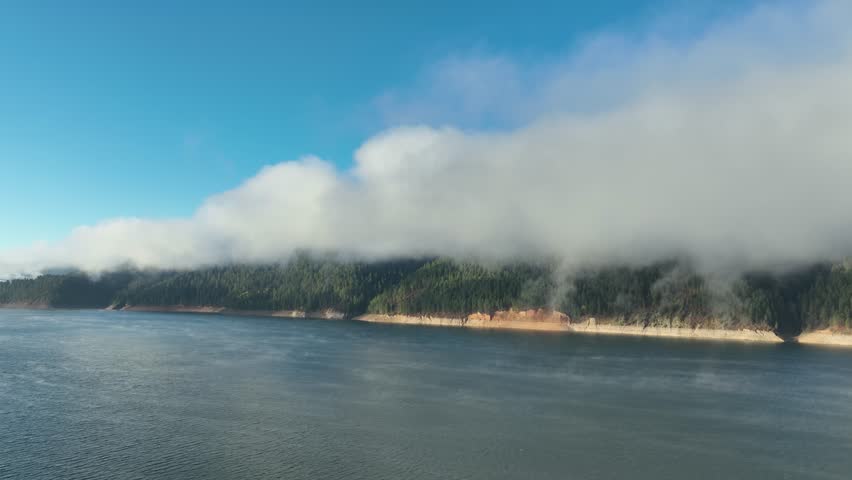 Aerial of low clouds above the Palisades Reservoir on the Snake River in Idaho. Mist if coming off the water.