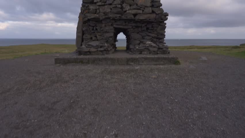 Iceland Arnarstapi Rock Sculpture Troll. Camera Tilts Up to Tall Rock Formation
