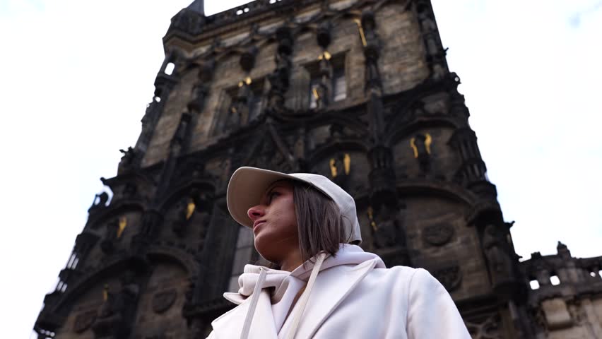Girl stand near impressive gothic style Powder Gate building exterior