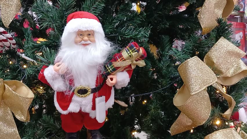 A Santa Claus puppet on a Christmas tree, with twinkling lights