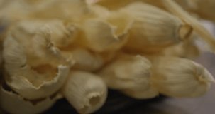 This close up video shows hands grabbing tamale corn husk.