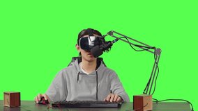 POV of streamer uses vr glasses to broadcast live action gameplay, sitting at his desk to play online videogames. Modern person content creator recording gaming stream, virtual reality headset.