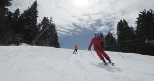 Female and male skiers skiing together on prepared slope. Couple having fun on skis. Si run 1 clip 3of5. Recorded on cinema camera 120fps.