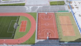 A complex of new sports facilities: a hockey field, a tennis court, a basketball court, running tracks and a football field in a new microdistrict. On football field are teenagers play football - Powered by Shutterstock - Get 15% off with code: PIKWIZARD15