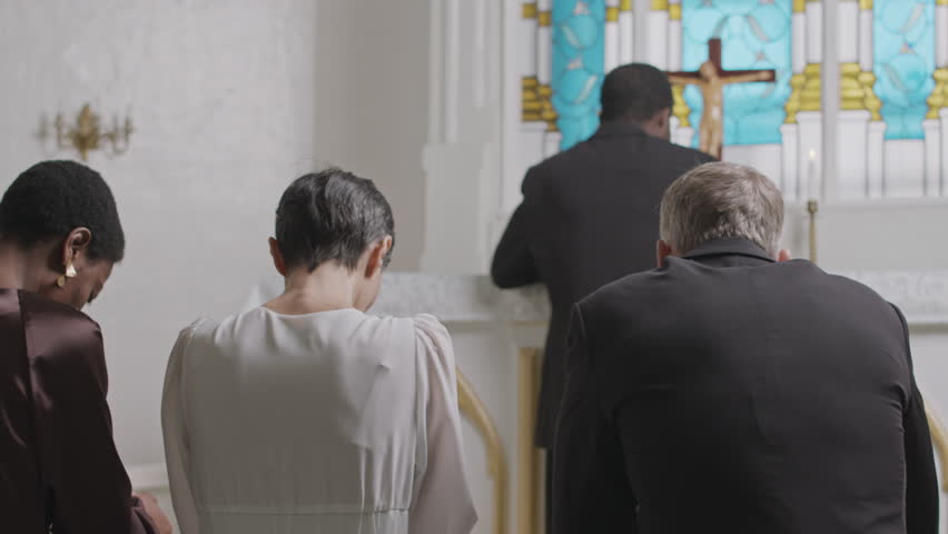 Back view of multiethnic people and priest praying with their heads down during religious service in Lutheran church Royalty-Free Stock Footage #3396425491