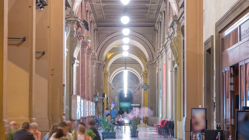 Arcade in building at Republic Square night timelapse with the arch in honor of the first king of united Italy, Victor Emmanuel II. Evening illumination. People walking inside. Florence, Italy