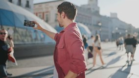 Handsome male tourist use smartphone camera for travel vlogging. Capturing travel selfie to share adventures with friends online in social media. Smiling man have video call during vacation holidays - Powered by Shutterstock - Get 15% off with code: PIKWIZARD15