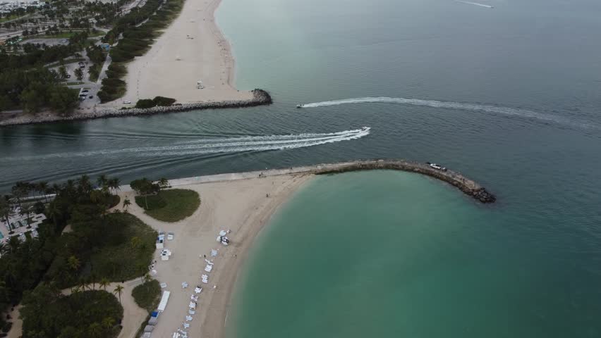 Aerial View Of Speed Boats Racing Across The Waterways Of Bal Harbour Village In Miami, Florida; Beautiful White Sand Beach Coastline.