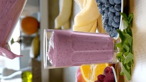 Raspberry Blueberry Melon Smoothie is poured into a glass on the background of fresh fruits and berries. Healthy and vegetarian food concept, Close-up, vertical footage - Powered by Shutterstock - Get 15% off with code: PIKWIZARD15