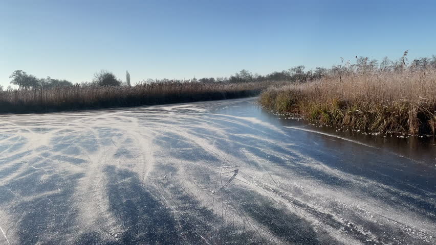 Point of View ice skating in the Weerribben Wieden nature reserve in The Netherlands during a beautiful winter day