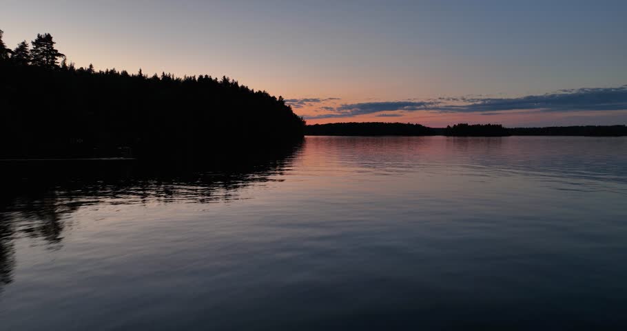 Aerial view of finnish lake vanaja and bridge during sunset in summer. Sunset reflections in the water. Golden hour in finnish nature. Birds flying over water