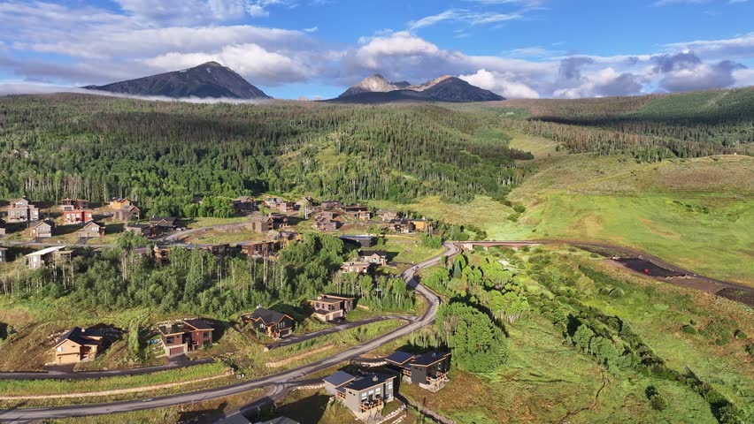 flying over a neighborhood of luxury homes in Silverthorne colorado with Buffalo Mountain and red peak in view and atmospheric mist in the mountains AERIAL DOLLY