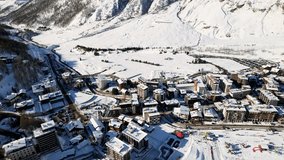 Panoramic aerial drone scenic view at ski slopes, mountain skiing and popular resort town. Italian ski resort in Alps in Aosta Valley in winter. Winter landscape. Italy, Breuil Cervinia. 4K video.