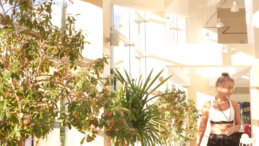 beautiful young woman, instructor of a luxury spa pool. passes by and smiles into the camera. 4k. Tropical trees in the spa pool