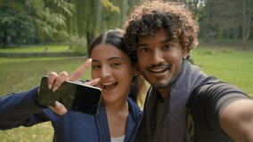 Indian Arabian couple girl guy man woman friends sport workout fitness exercise fit make selfie photo with phone smiling posing video call streaming bloggers vloggers influencers in park outdoors