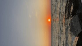 Summer sunset seascape. Sea and golden sunset. Vertical video.
