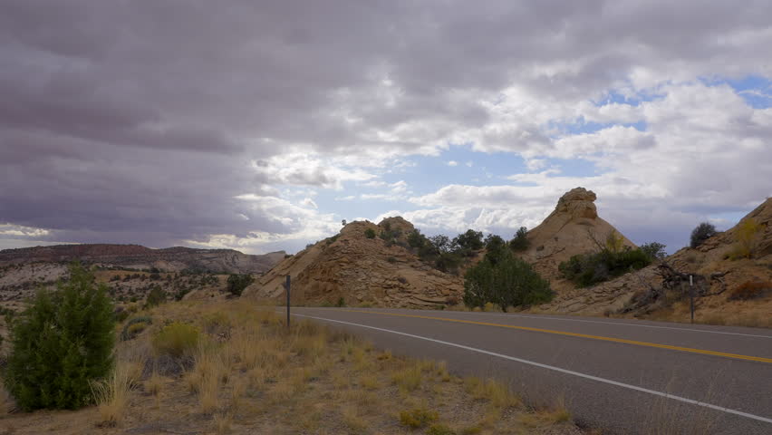 Establishing shot of brown mountains with green forest in The Hogback Scenic Root 12, Utah, North America. Day time on October 2023. ProRes 422 HQ.