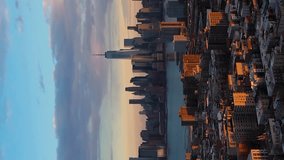 Lower Manhattan, Jersey City and Hudson River. New York at Sunset. Sunlight on Buildings. Aerial View. United States of America. Drone Flies Sideways and Upwards. Vertical Video
