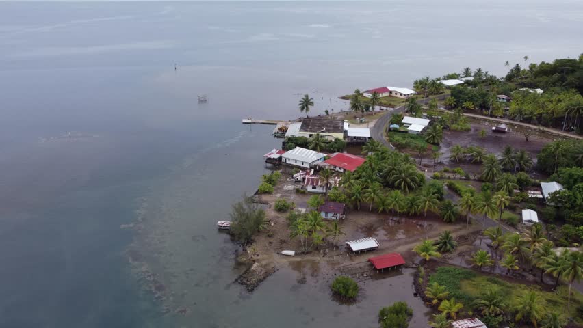 Low wet shoreline village on tropical Polynesian island of Taha