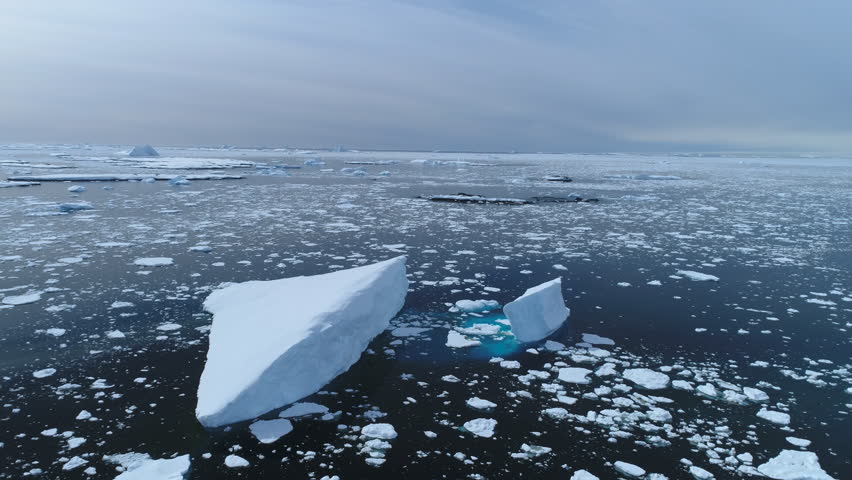 Antarctica melting blue water iceberg aerial view. Antarctic ocean environment. Ice nature landscape of global warming and climate change concept. Top Drone Shot Footage