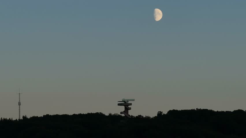 Moon disappearing from view, Wilhemina tower under fading sunset. Aerial
