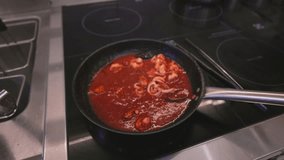 Italian Pasta Cooking Process with seafood. Cooked pasta is mixed with sauce and toppings in a hot pan. Italian cuisine, traditional recipe. Slow motion video