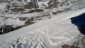 Panoramic aerial drone scenic view at ski slopes, mountain skiing and popular resort town situated on border Switzerland and Italy. Winter landscape 