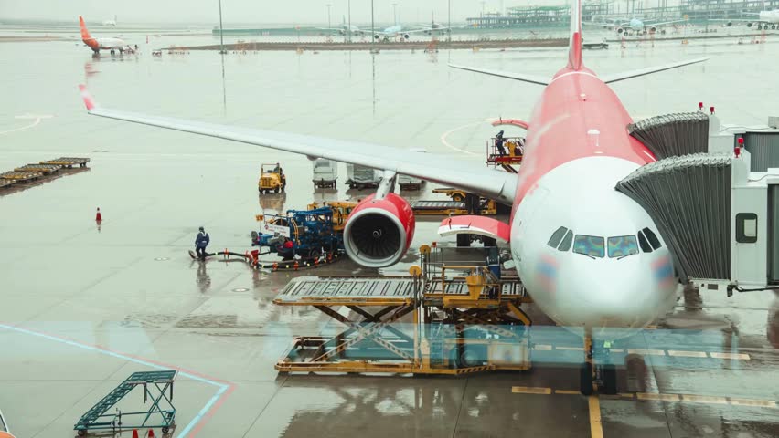 Airplane in the airport after rain loading luggage. A rainy day in Airport. airplane being filled with supplies at Airport on a rainy day. International transport, airmail and logistics concept. Royalty-Free Stock Footage #3397104141