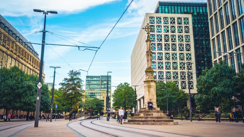 Time lapse of Crowd people and commuter pedestrians crossing street and walking at St. Peter's Square station area in downtown district of Manchester City, United Kingdom