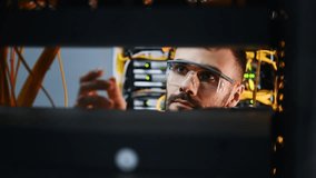 Young man is working with internet equipment and wires in server room - Powered by Shutterstock - Get 15% off with code: PIKWIZARD15