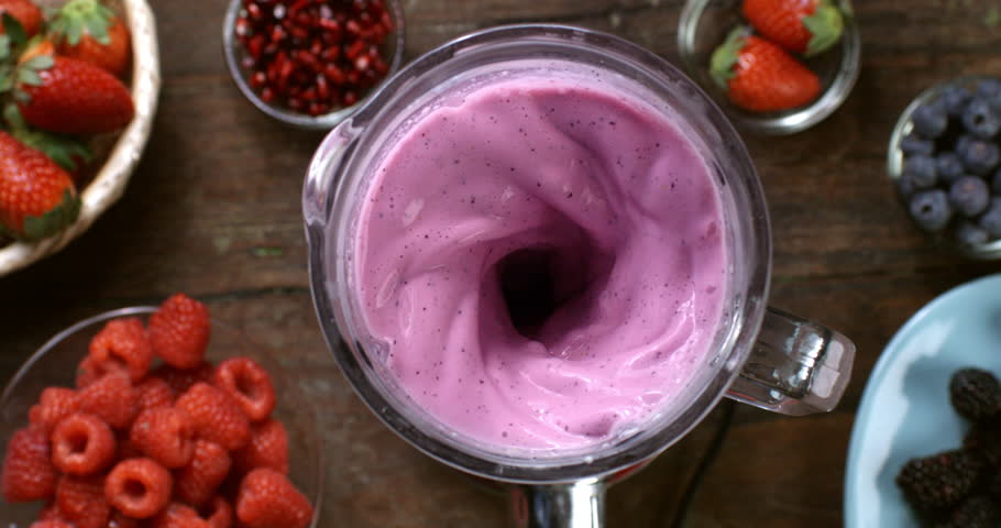 Collage of super slow motion of dietetic milkshake smoothie cocktail of organic fresh vegetables being mixed in blender at 1000 fps on wooden table of restaurant.