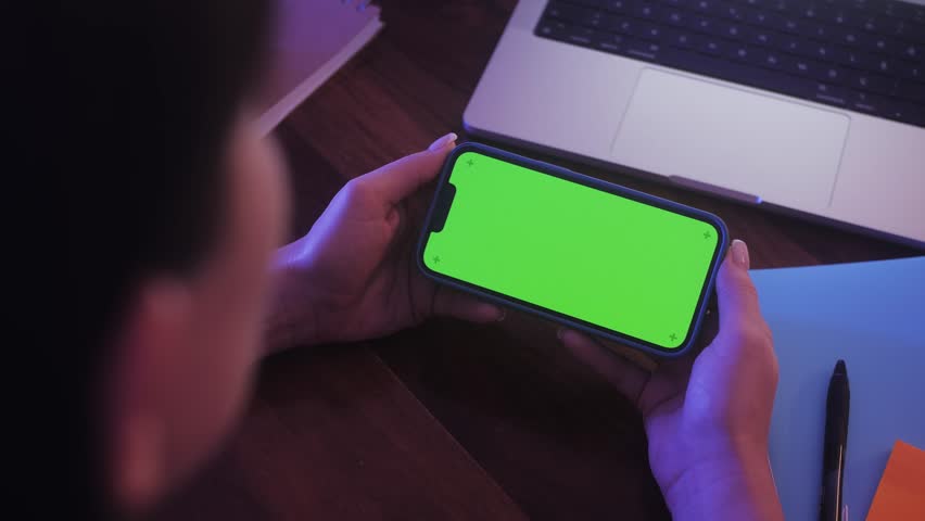 Close up Horizontal hands holding smartphone with green screen. Green screen mobile phone with chroma key.