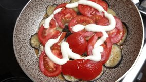 Vegetable stew of eggplants and tomatoes with garlic and mayonnaise. Slow motion. Top view. Cooking master class. Video recipe. Home cooking.