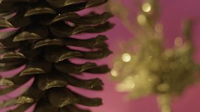 Christmas tree cone with a green new year tree in front of a beautiful flashing color background. Slow motion, 8K downscale, 4K.