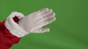 Vertical video of santa claus hand saying hello over green screem chroma key background. Christmas, tradition and celebration concept.