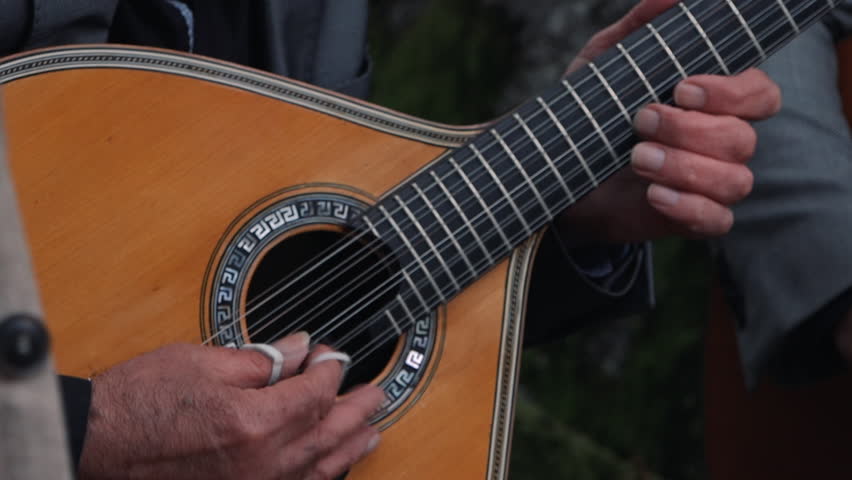 Strumming a Portuguese guitar outdoors. Close up Royalty-Free Stock Footage #3397423021