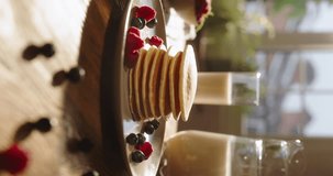 Classic American breakfast with fluffy pancakes topped with luscious berries and drizzle of syrup. Joy of cooking, healthy eating for family's everyday weekend recipes. Glass of milk. Vertical video