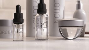 Close-up of skincare bottles in 3D animation, showcasing modern design with clean lines and transparent materials on a reflective surface. 3D Illustration - Powered by Shutterstock - Get 15% off with code: PIKWIZARD15