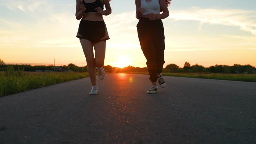 two friends running sunset, team group girls running sunset, silhouette athletic girls, teamwork legs athlete running road, training running health, club like-minded people, outdoor exercise, you can Royalty-Free Stock Footage #3397530387