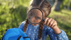 the girl holds magnifying glass in her hands. gaining knowledge and curiosity concept. a schoolgirl girl with a lifestyle black magnifying glass is examining something, park on the background - Powered by Shutterstock - Get 15% off with code: PIKWIZARD15