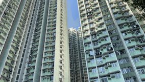 Exterior video film motion footage of a steady framing on a construction tower building complex wth council flats and apartments on a clear blue sky with nice weather day in Hong Kong