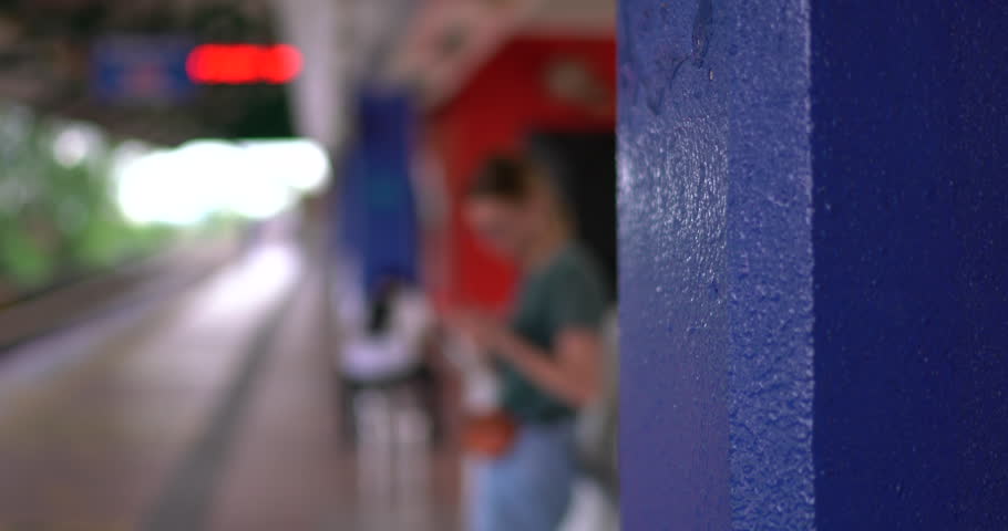 Casually dressed tourist making phone call using international roaming tariff for connection standing on metro platform
