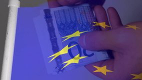 Animation of flag of european union over euro currency bills. Global finance, business, connections, computing and data processing concept digitally generated video.
