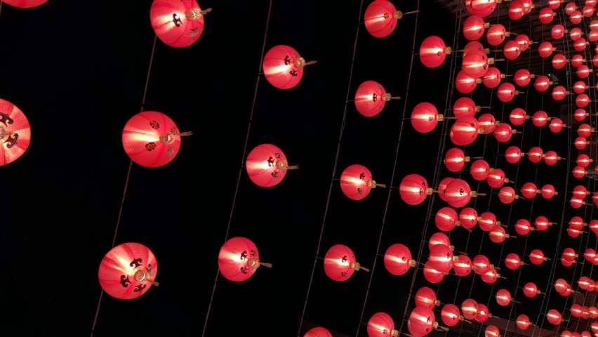 Vertical video. Chinese red lanterns symbolize wealth and happiness at night. Lunar New Year celebration.