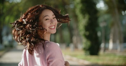 close-up of beautiful Asian girl in Sunny day in the Park,turn on the camera with a smile slow motion