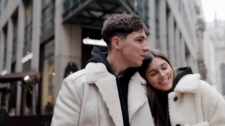 Couple in love standing together, hugging and smiling, on the street. Steadicam shot. Milan, Italy