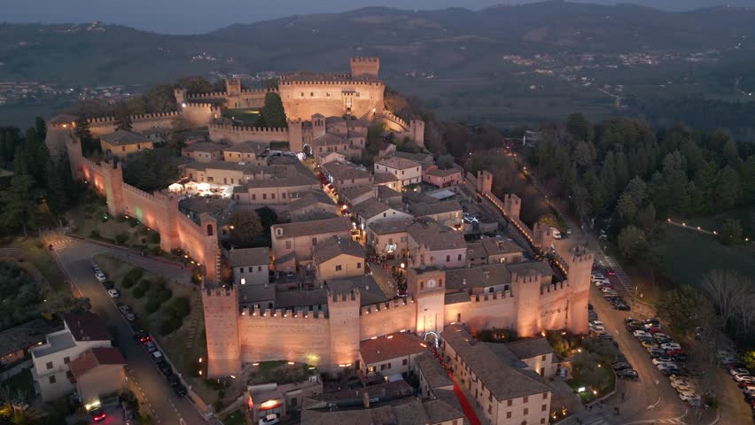 Italy, 14 December 2023 - Night aerial view of the medieval village of Gradara on the border with Romagna in the province of Pesaro and Urbino in the Marche region Royalty-Free Stock Footage #3397857689